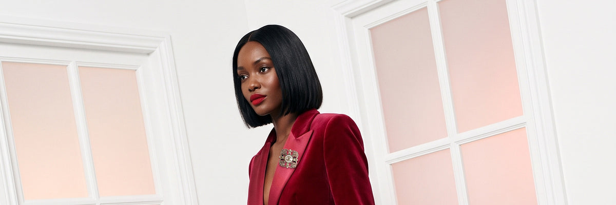 Gifts for her: a model in a ruby velvet jacket with a jewelled brooch