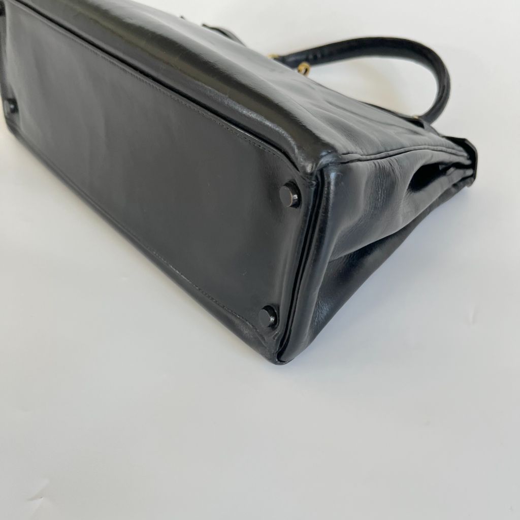 Lot - Hermés Black Box Leather Kelly Retourne 32 Handbag, Date Code 1981,  with Clochette, Keys, Lock and Replacement Dust Bag, Height: 9 in (22.9  cm); Length: 12-1/2 in (31.8 cm); Depth: 4 in (10.2 cm)